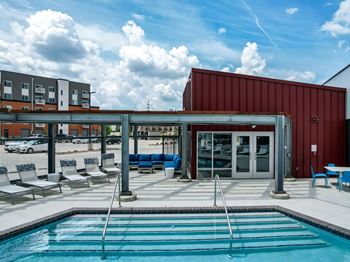 A pool area with a red building and a white building in the background.at Linc, Iowa   